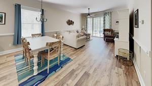 a living room with a table and a couch at Tranquil Hideaway 4 Bdrm Condo in Avian Forest in Pawleys Island