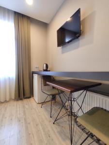 Habitación con mesa y TV en la pared. en Ore Pera Suites en Estambul