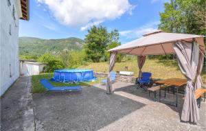 patio con tavolo, sedie e ombrellone di Pet Friendly Home In Bergotto With Outdoor Swimming Pool a Roccaprebalza