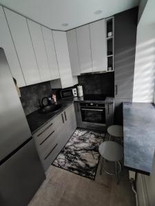 una piccola cucina con armadi bianchi e lavandino di Miesto šviesų apartamentai Telšiuose a Telšiai