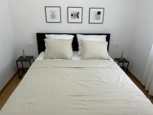 Apartment Marta في أوربيك: غرفة نوم بسرير ذو شراشف ووسائد بيضاء