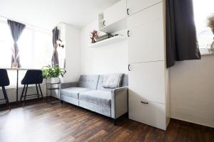 a living room with a couch and a table at Stilvolles Ruhiges Studio - PARKPLATZ, WIFI, TV EM-APARTMENTS DEUTSCHLAND in Bielefeld
