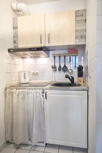 a kitchen with white cabinets and a sink at Stilvolles Ruhiges Studio - PARKPLATZ, WIFI, TV EM-APARTMENTS DEUTSCHLAND in Bielefeld