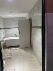 baño con bañera, aseo y puerta en Nandoni Waterfront Resort en Vendaland