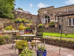 a patio with a table and chairs and plants at The Stables in Sedbergh