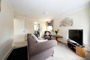 a living room with a couch and a television at Pure Apartments Commuter- Dunfermline South in Fife
