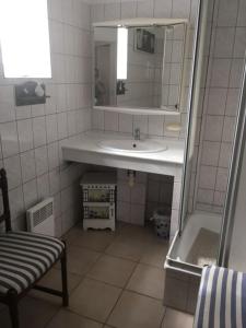 a bathroom with a sink and a mirror and a chair at LE clos do ré in Sainte-Marie-de-Ré