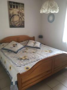 a wooden bed with a quilt on it in a bedroom at LE clos do ré in Sainte-Marie-de-Ré