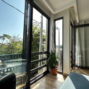 Luxurious Green Garden Flat by SUMMITVISTA في إسطنبول: غرفة مطلة على شرفة مع نوافذ