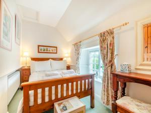 1 dormitorio con cama y ventana en Maple Cottage, en Slingsby