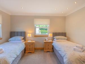 two twin beds in a room with a window at The Potting Shed in Challoch