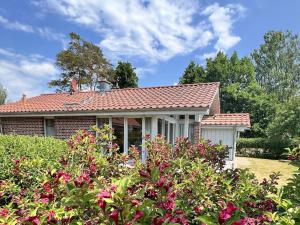 a brick house with a red roof and some flowers at Ferienhaus Müritzhus an der Müritz in Marienfelde