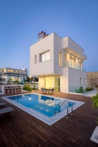 a villa with a swimming pool in front of a house at City Napa Seaview Villas in Ayia Napa