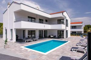 a villa with a swimming pool and a house at Villa Gräfin in Malinska