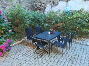 a black table and chairs with flowers on a patio at Ferienwohnung Natalie in Kaisersesch