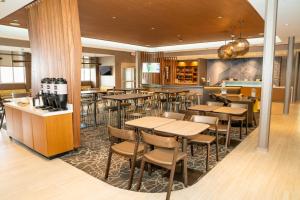 SpringHill Suites by Marriott Woodbridge في وودبريدج: مطعم بطاولات وكراسي وبار