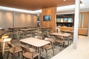 a restaurant with tables and chairs and a bar at SpringHill Suites by Marriott Woodbridge in Woodbridge