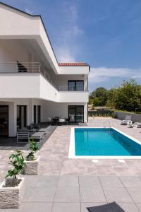 a villa with a swimming pool and a house at Villa Gräfin in Malinska