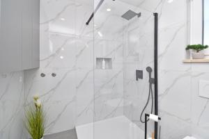 a bathroom with a shower with white marble walls at Luxury Apartments Luna in Tučepi +67 photos