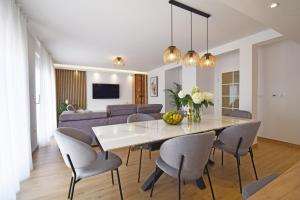 comedor y sala de estar con mesa y sillas en Luxury Apartments Luna, en Tučepi
