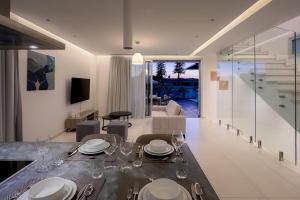 a dining room with a table with plates and wine glasses at City Napa Seaview Villas in Ayia Napa