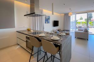 a kitchen with a island with a sink and a table at City Napa Seaview Villas in Ayia Napa