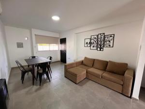 ein Wohnzimmer mit einem Sofa und einem Tisch in der Unterkunft Departamento Nº 3 en complejo semiprivado! 2 habitaciones in San Martín