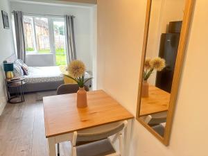 Habitación pequeña con mesa y espejo. en Flat 04 Studio flat close to Aylesbury town and Station Free Parking en Buckinghamshire