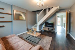 a living room with a couch and a tv at Simitach Serviced Apartments in Middleton