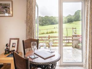 a dining room with a table and a view of a field at Molehill Lodge in Ammanford