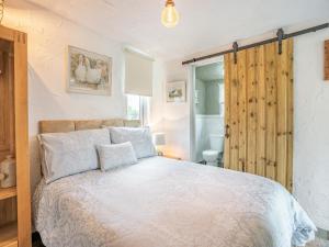 a bedroom with a large white bed and a window at Molehill Lodge in Ammanford