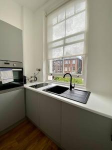 une cuisine avec un évier et une fenêtre dans l'établissement Studio for 3 near Regents Park n5, à Londres