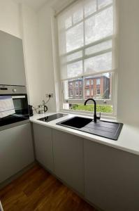 uma cozinha com um lavatório e uma janela em Studio for 3 near Regents Park n5 em Londres