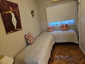 Duas camas num pequeno quarto com uma janela em Brisas de Recoleta em Buenos Aires