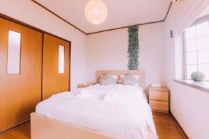 a bedroom with a white bed with a wooden headboard at Huge Osaka Castle House - local vibes quiet area in Osaka