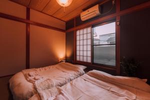 a room with a bed and a window in it at Huge Osaka Castle House - local vibes quiet area in Osaka