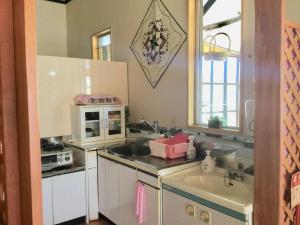 eine Küche mit einer Spüle und einer Mikrowelle in der Unterkunft Guesthouse Yu Yu - Vacation STAY 14848 in Wakkanai