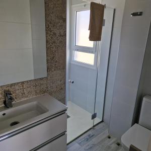 a bathroom with a sink and a shower at Costa Luz Sirens Beach in Los Pocillos
