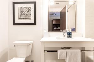 a white bathroom with a sink and a toilet at Four Points by Sheraton Kelowna Airport in Kelowna