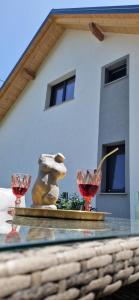 zwei Weingläser auf einem Glastisch vor einem Haus in der Unterkunft Apartment Stella Danica in Čatež ob Savi