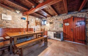 a large kitchen with a wooden table and benches at Cozy Home In Plomin With Kitchen in Plomin