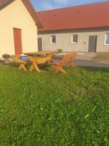 a picnic table in the grass in front of a building at Domek w górach 2 in Lubawka