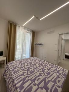 um quarto com uma cama roxa e branca e uma janela em Villa Family House , Senigallia , Trecastelli (AN) em Molino di Ripe
