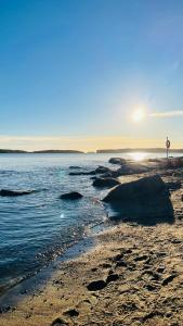 una spiaggia con il sole che sorge sull'acqua di Modern family apartment next to metro easy access to Helsinki a Espoo
