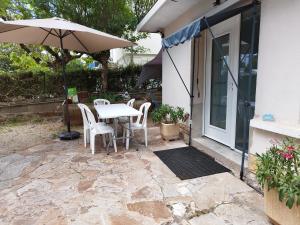 a patio with a table and chairs and an umbrella at Ruthene Etape Appartement T3 in Rodez