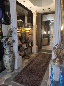 un vestíbulo con una tienda con un jarrón y columnas en D'Elite Room & Breakfast, en Ferrara