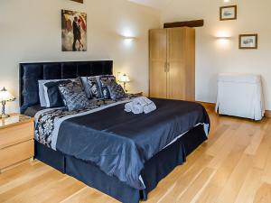 1 dormitorio con 1 cama grande con sábanas y almohadas azules en Blackberry Barn en Tortworth