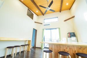 a bar with stools in a room with a ceiling at Guest house KURIHAI - Vacation STAY 09979v in Oita