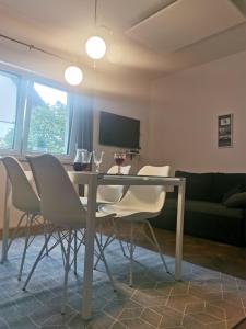 un tavolo da pranzo con sedie bianche in soggiorno di Apartment Stella Danica a Čatež ob Savi
