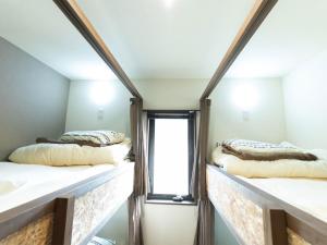 two beds in a room with a window at Guest house KURIHAI - Vacation STAY 09979v in Oita